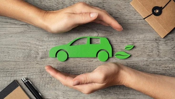 Mani che circondano una figura di auto verde con foglie, simbolo di ecologia e sostenibilità.