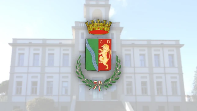 Stemma del Comune di Porto Viro con sfondo di edificio storico, simbolo ufficiale della città.